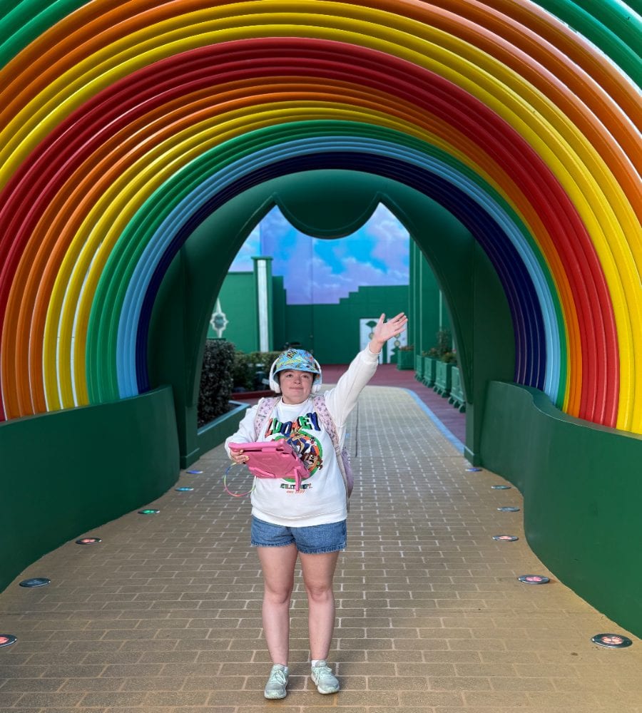 A Happy Human beaming under a rainbow archway